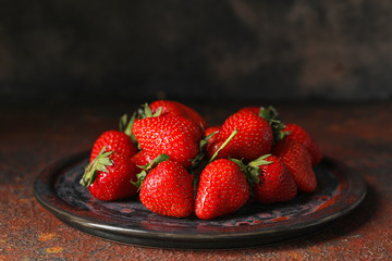 Plate with ripe strawberry on table