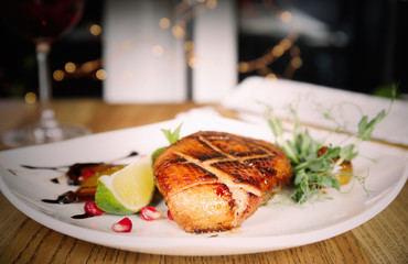 Delicious grilled duck breast served on wooden table indoors, closeup. Food photography