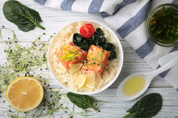 Tasty salmon with rice and spinach on white wooden table, flat lay. Food photography
