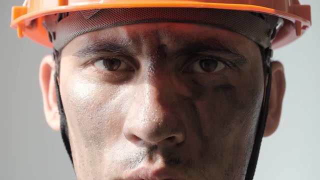 Portrait Dirty Mine Worker. Beautiful Caucasian Man in a Hard Hat. Filthy Job and Physical labor. Coal mining. People Working Equipment. Looking at Camera. Close up