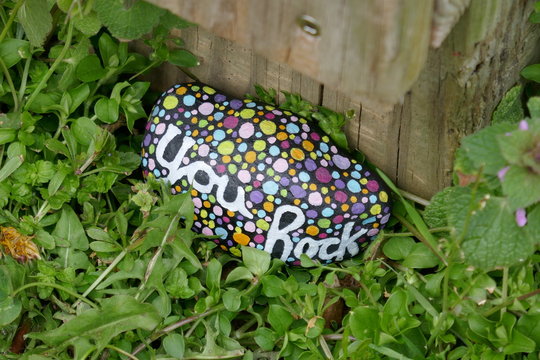 Kindness rock painted with colorful spots and encouraging message