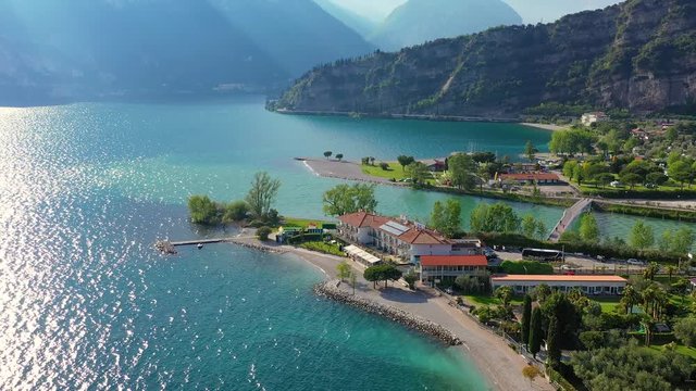 Aerial video with drone, view of the Torbole a small town on Lake Garda, Italy. Europa.beautiful Lake Garda surrounded by mountains in the summer time