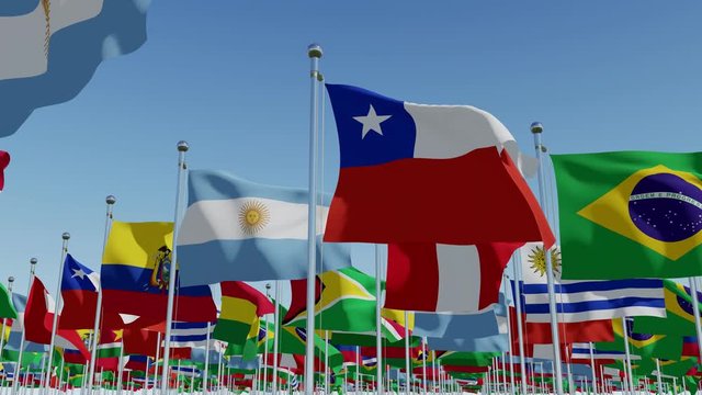 Many flags of South America continent on flagpoles against blue sky. 3d rendering animation.