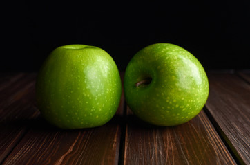 Fresh green apples on dark rustic woden background.
