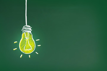 Light bulb drawing as symbol of idea on green chalkboard - Powered by Adobe
