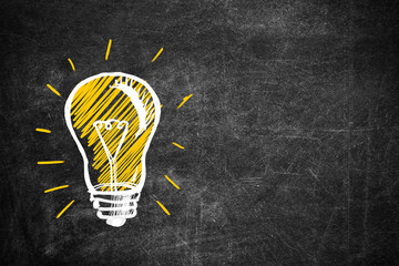 Light bulb drawing as symbol of idea on chalkboard