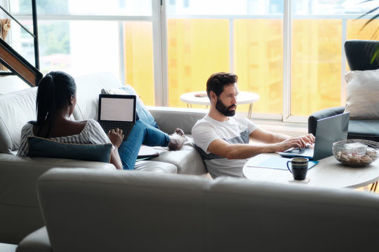 Couple Working And Playing With Laptop Computer At Home