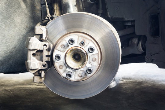 Rear wheel hub and car disk brake on background, detail of the rear wheel hub
