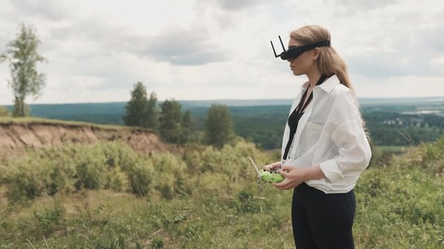 Girl in black FPV glasses and a racing drone control panel