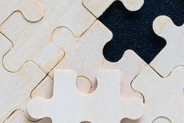 wooden jigsaw puzzle pieces on black background