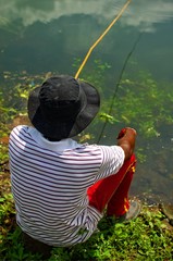 A person is sitting near river to catch fish