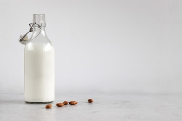 bottle with almond milk on a grey background, no gluten, horizontal orientation, isolated