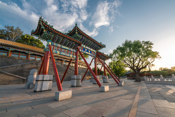 Naklejka premium Memorial archway with beautiful sunset in Beihai park, Beijing, China. Translation: Accumulation of jade.