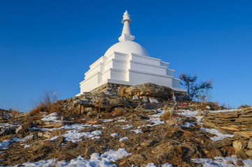 An iconic white Buddhist stupa on small sacred hill in lake Baikal, Russia. Tibetan Buddhism...