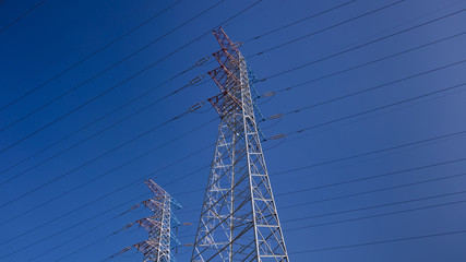 High power electricity poles connected to smart grid at clear sky