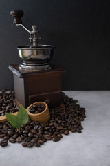Coffee beans with coffee grinder on vintage black fabric background.