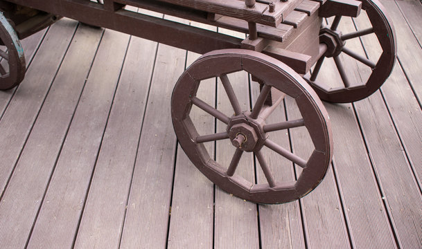 Old wooden cart. Wheels made of wood. Platform of boards. Brown color. Concept of vintage scenery, dray, wain.