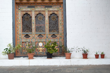 Fototapeta na wymiar Potted Plants against White Bricks and Window in Bhutan