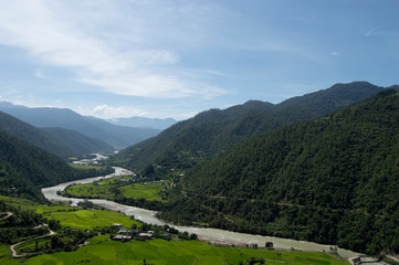 Fototapeta na wymiar Long Beautiful Winding River in Bhutan Surrounded by Rolling Green Hills