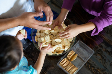 Obraz na płótnie Canvas Kids making Kek Batik or Malaysian Triple Chocolate Dessert. Doing the initial steps, crushing the cookies into tiny pieces.