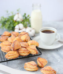 curd cookies with a cup of coffee on light table with cotton flower