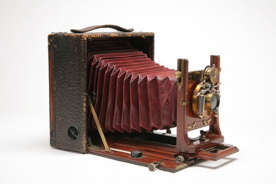 Vintage large-format view camera with bellows extended.  Three-quarters view, shot of white background	