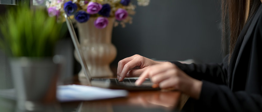 Side view of businesswoman working with laptop and document paper in coffee shop