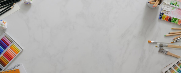 Top view of modern workspace with copy space, painting tools and stationery