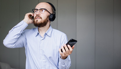 Obraz na płótnie Canvas Man listening to music on mobile phone in living room