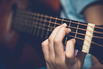 Fototapeta na wymiar Close up of young girl hand playing guitar