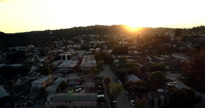 Covid-19 Coronavirus causing empty streets and avenues in North East Los Angeles, California. Aerial drone view looking towards the sun as its setting with mountains of Glassell Park. high contrast.