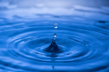 Water drop close up of in a blurred blue background