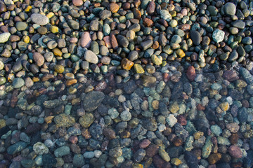 Colourful pebbles at under a very clear ocean water the sea shore