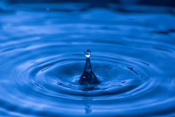 Water drop close up of in a blurred blue background