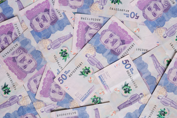 Many 50000 Colombian bills on flat background surface close up. Flat lay top view