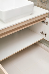 Fototapeta premium detail of cupboard or wardrobe under sink in bathroom, built-in furniture in modern condominium