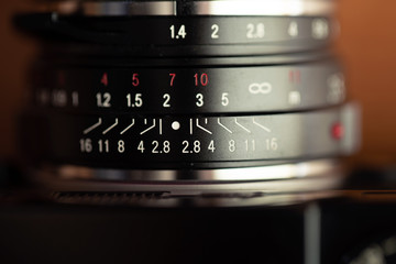 Focus dial of a vintage manual lens. infinity on a scale of the lens close-up, macro shot /...