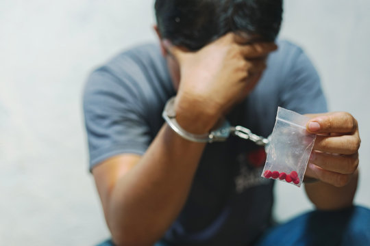 Drug Dealer Under Arrest Confined With Handcuffs And Hands, Sale Of Drugs Is Punishable By Law.