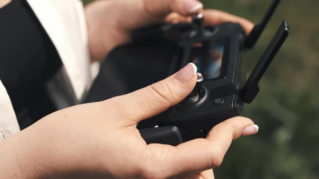 Female hands holding a controller from a drone
