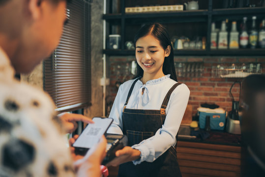 Customer paying with qr code on smartphone screen NFC payment technology at coffee shop.
