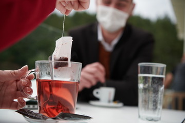couple with protective medical mask  having coffee break in a restaurant
