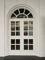 Antique white door in the white wall, classic decorative architectural design