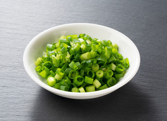 Carved green onions placed on a black background