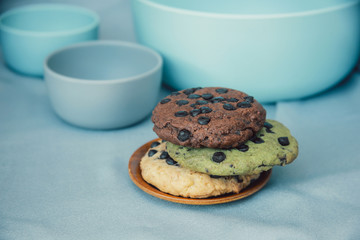 chocolate chunk cookies on a bright blue  with bowl set as background. Food photography style