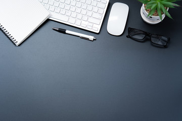 Top view with laptop, mobile phone, coffee cup, pencil, pencil and glasses placed on a black background