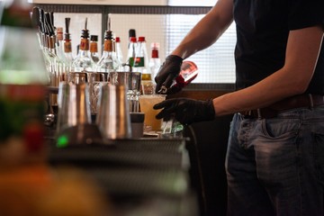 restaurant worker with gloves preparing mixed drink