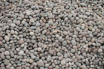 Bunch of small gray round pebblestones. Beach stones on a pile