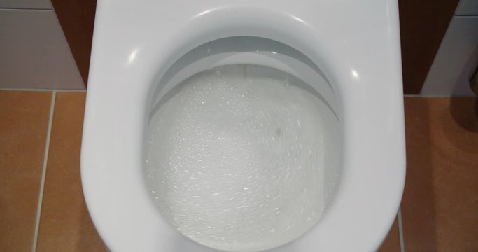 Pressing the toilet flush button, tilt-down to flushing with water in slow motion
