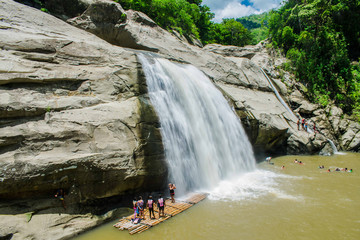 Tourist taking selfies at a floating bamboo boat at the foot of the Tangadan Fall located at La Union Pangasinan Philippines