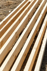 Timber and construction beams are lying on the construction site. Preparing for the construction
